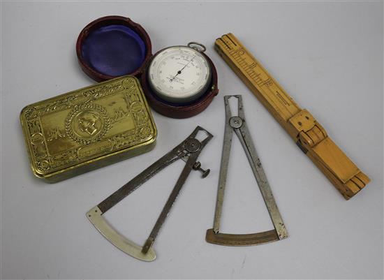 A foot measuring ruler, barometer, instruments and a WWI brass tobacco tin